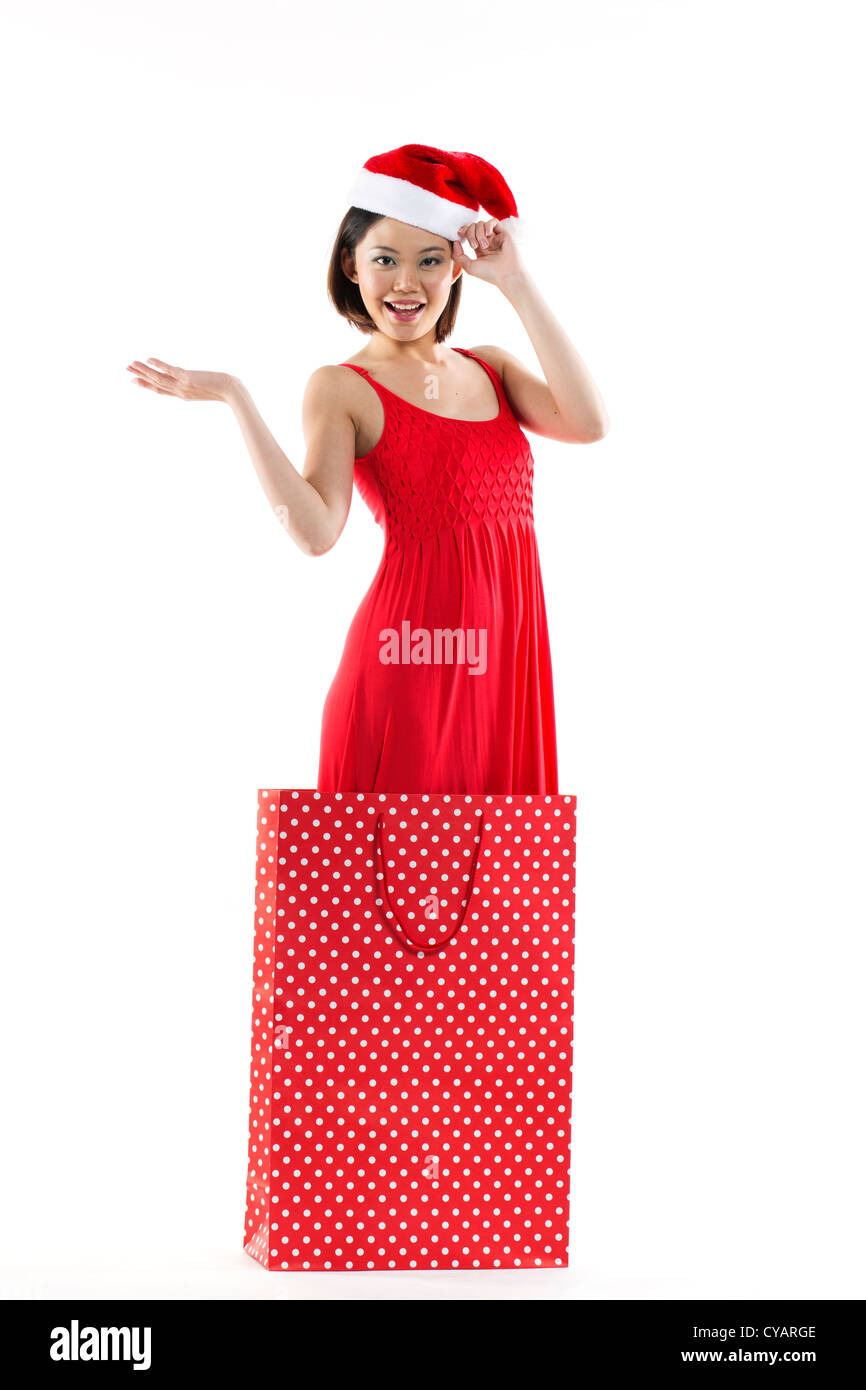 Happy Chinese girl jumping out of a bag wearing a santa hat Stock Photo ...