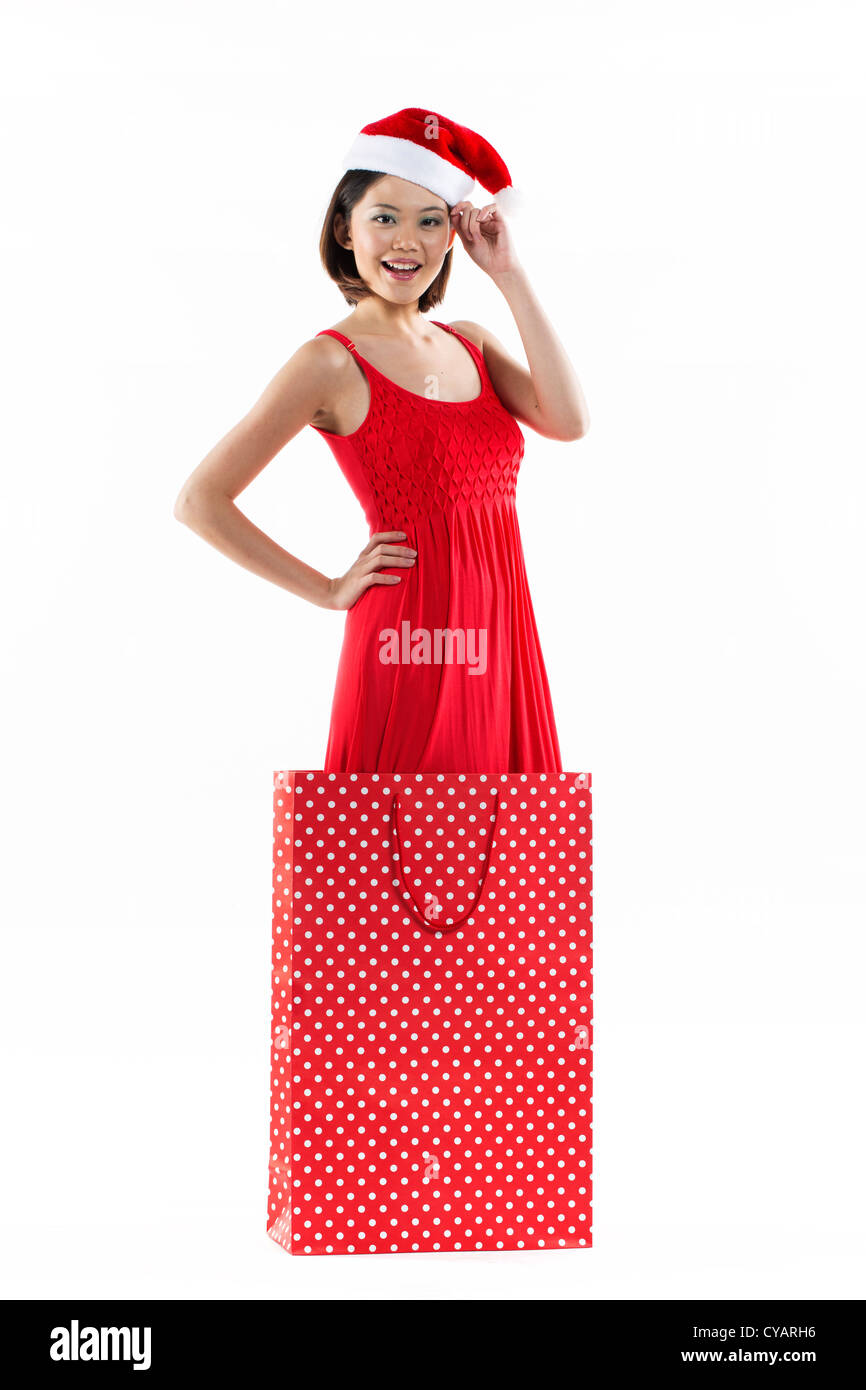 Happy Chinese girl jumping out of a bag wearing a santa hat Stock Photo ...