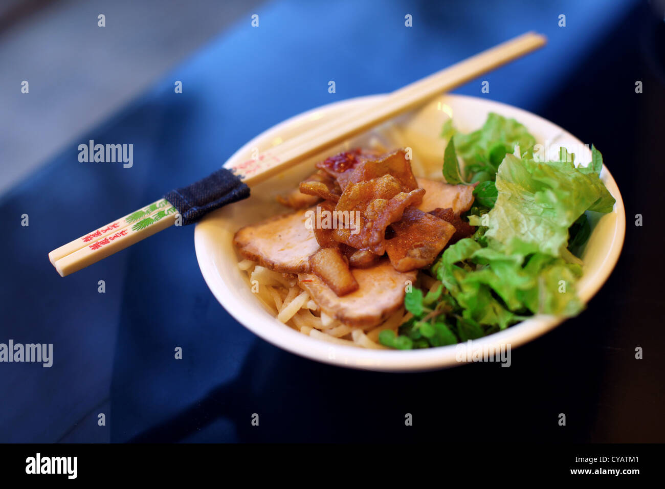 Pork fried and sliced on salad and rice noodles Stock Photo