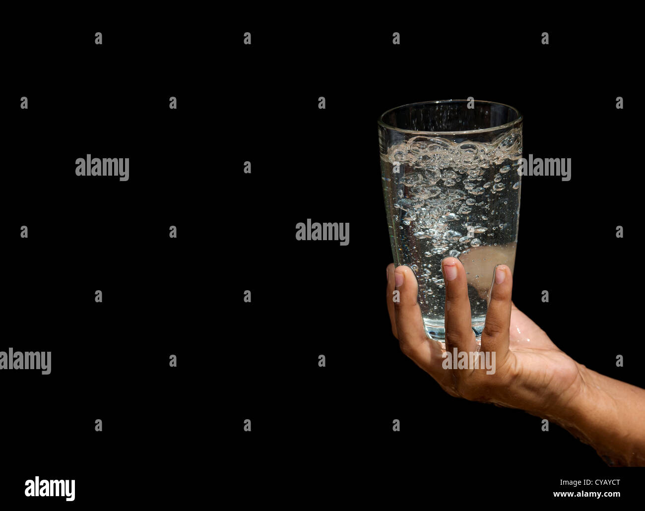 Bubbling water in a glass held by Indian girls hands Stock Photo