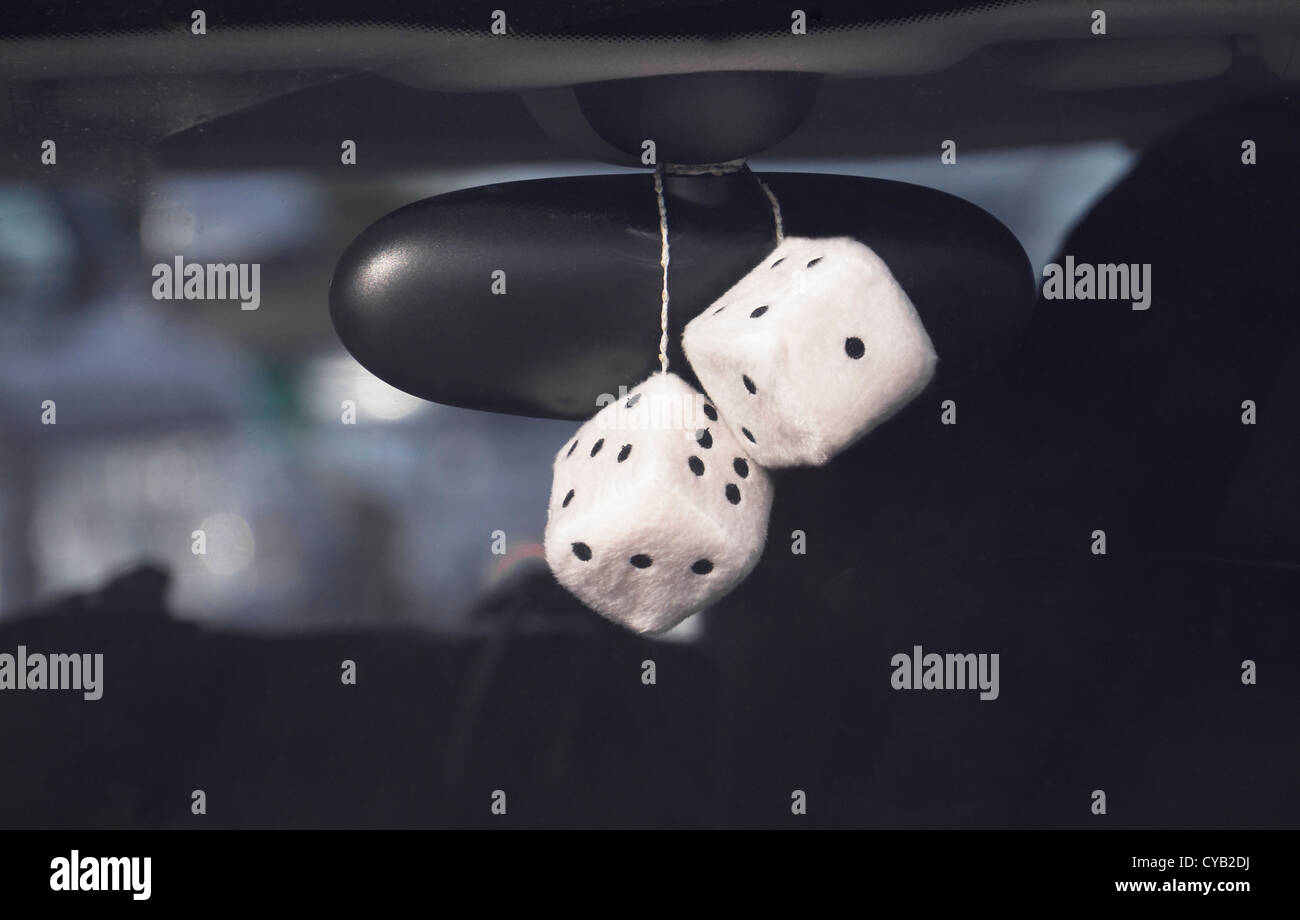 Fluffy dice hanging off the rear view mirror of a car. Stock Photo