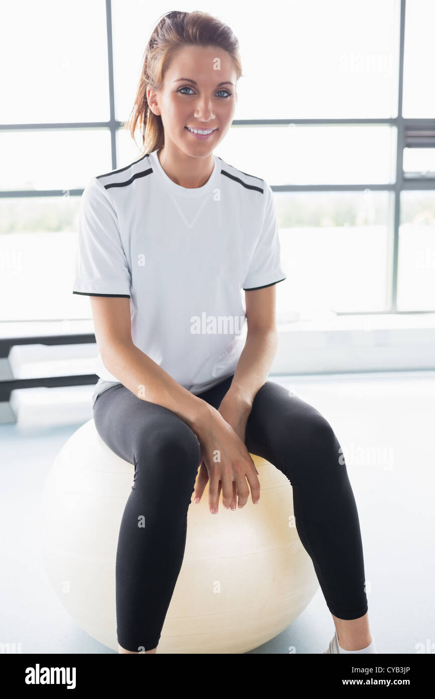 Smiling woman sitting on exercise ball Stock Photo - Alamy