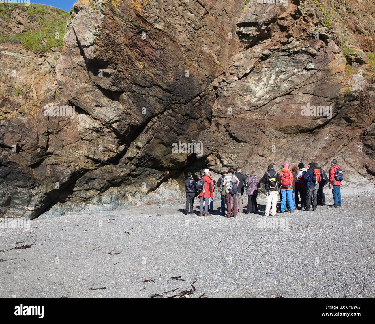 Geologists study rocks in cliffs at Lizard Point, Cornwall, England