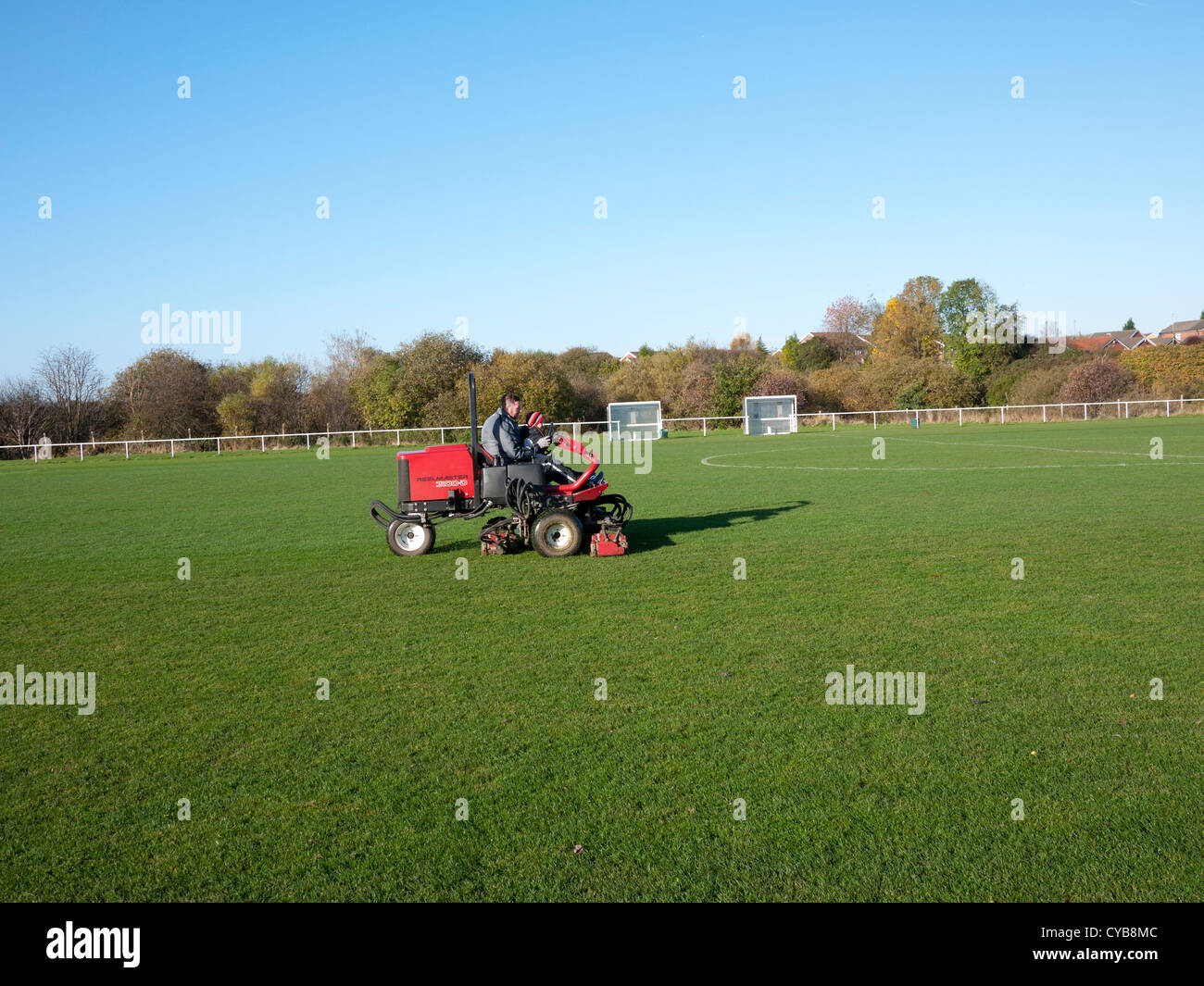 Man trimming football pitch with an industrial Mower, England, UK. Stock Photo