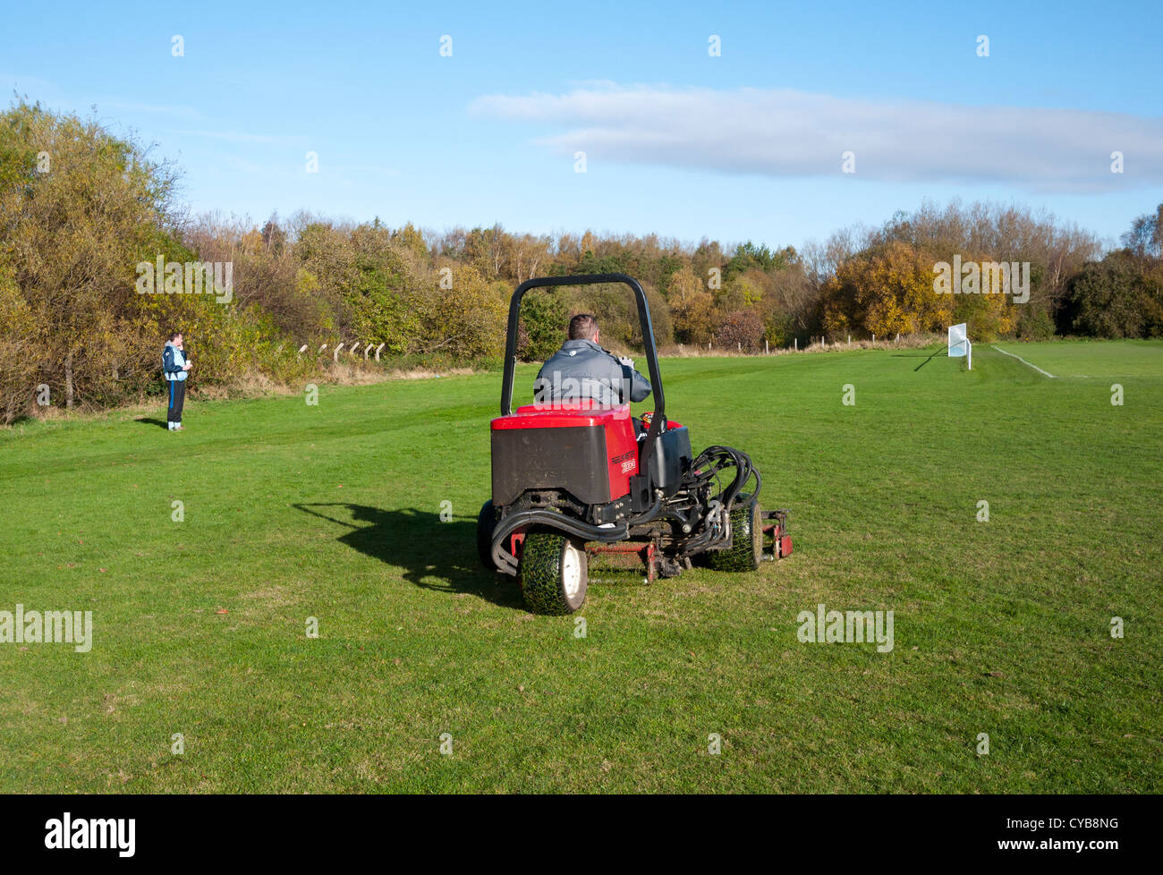 Man cutting grass on a industrial type grass cutter, England UK. Stock Photo
