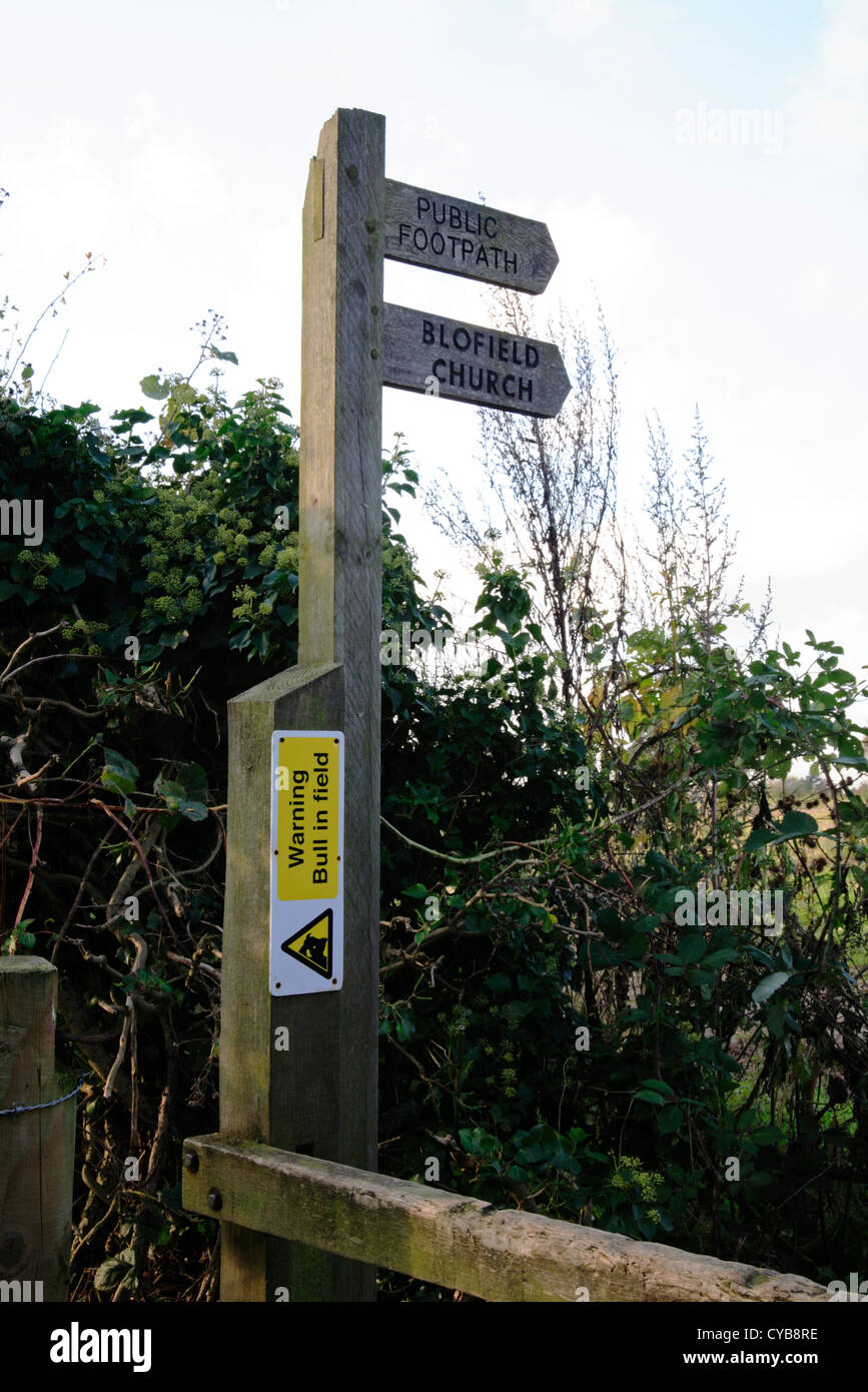 Fingerpost for footpath route with Bull in Field warning sign at Braydeston, near Brundall, Norfolk, England, United Kingdom. Stock Photo