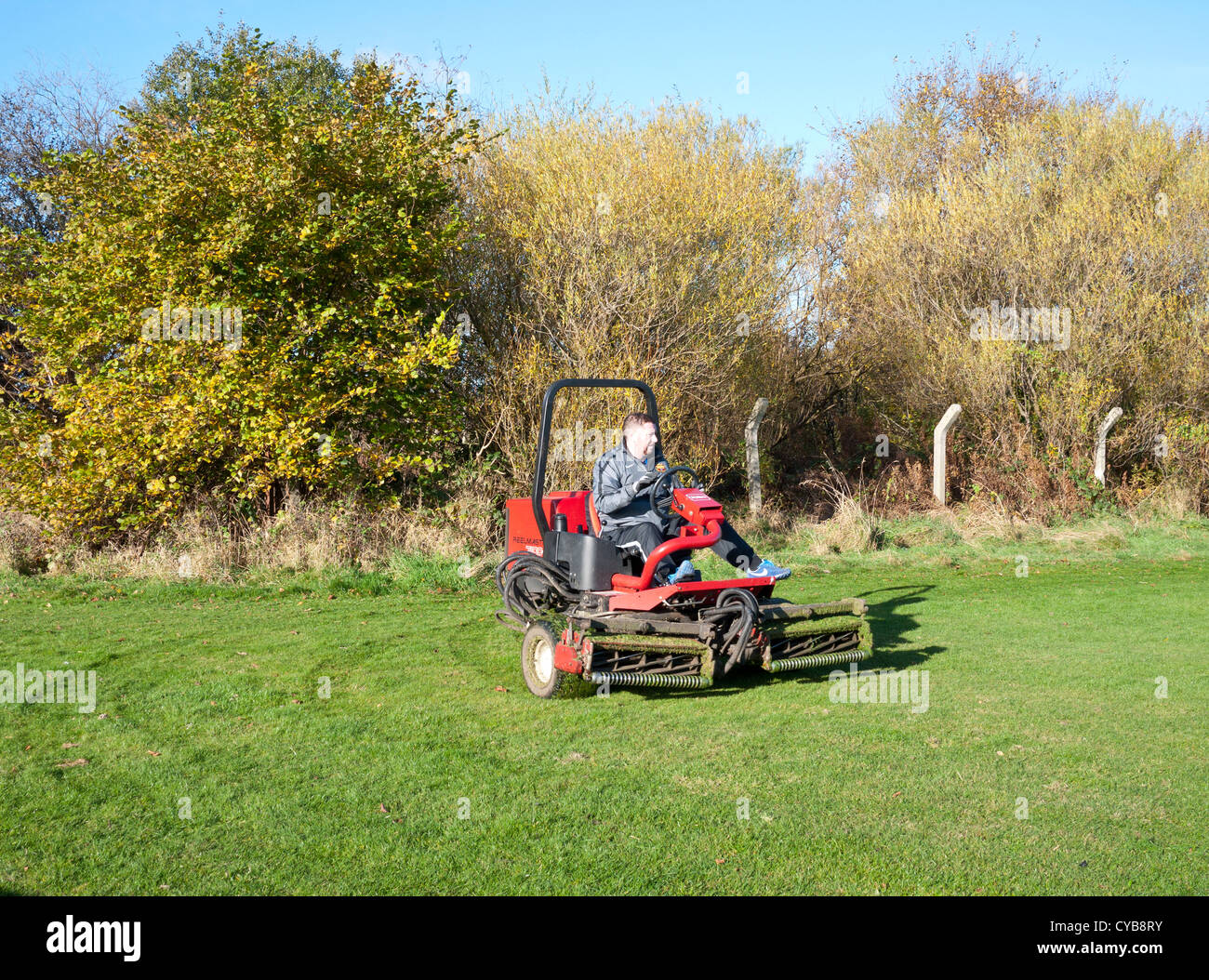 Man cutting grass on a industrial type grass cutter, England UK Stock