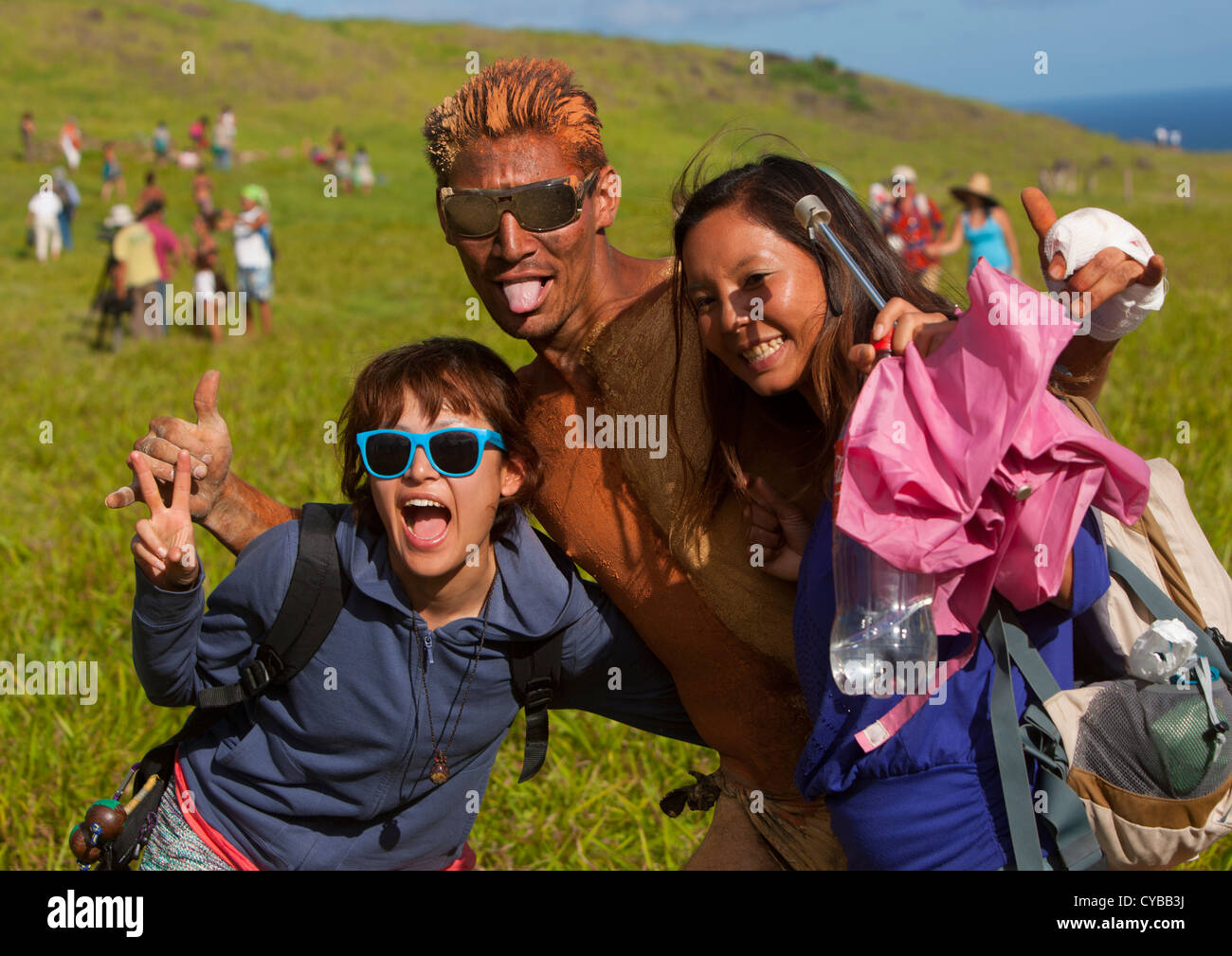 Japanese Tourists Pausing With A Rapanui Man After His Banana Haka Pei Competition, Easter Island, Chile Stock Photo