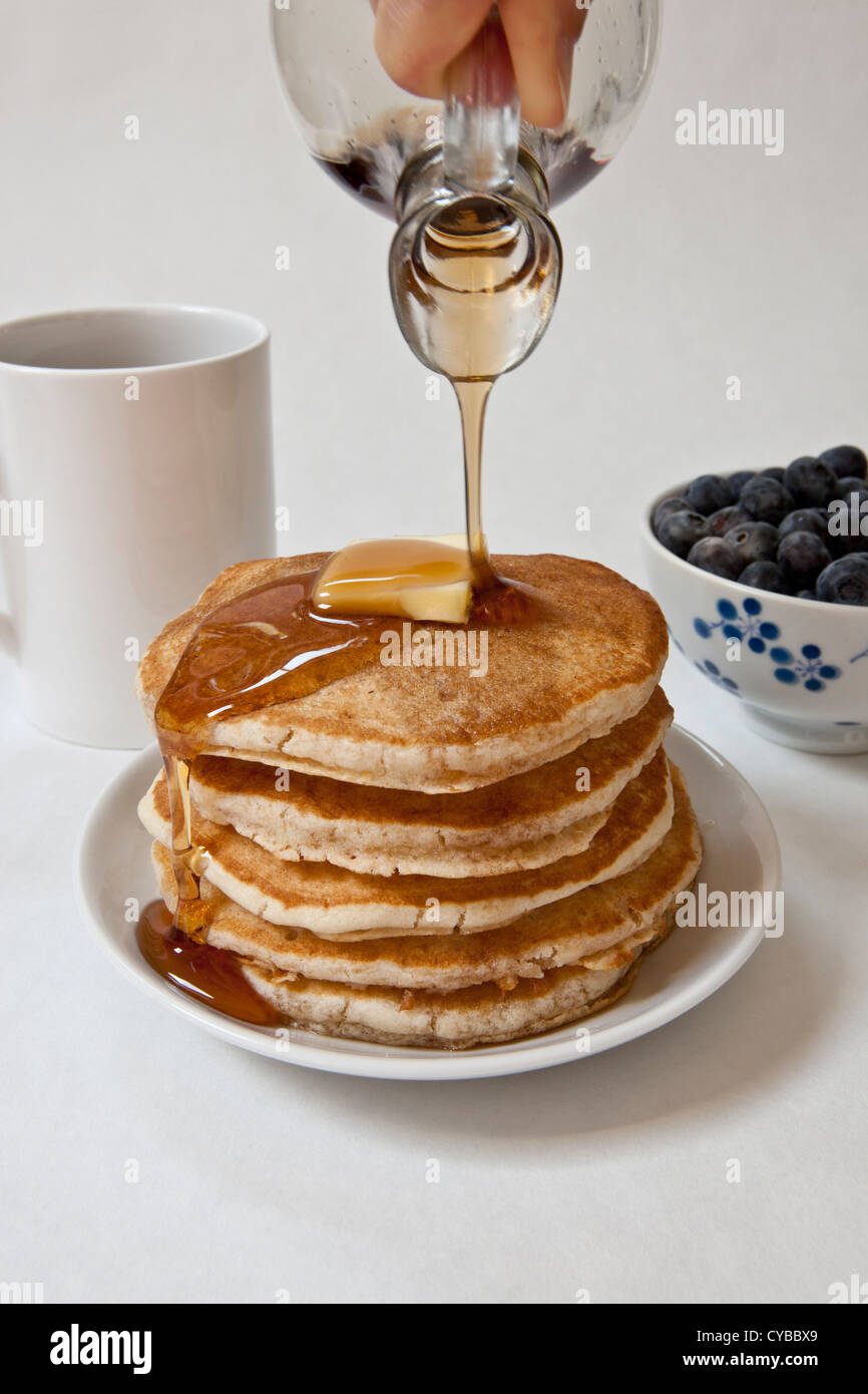 Pouring maple syrup on a stack of pancakes Stock Photo Alamy