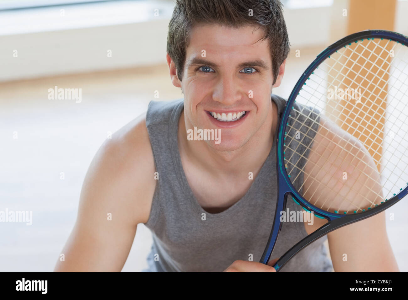 Man Using Tennis Racket Happy man holding a tennis racket Stock Photo - Alamy