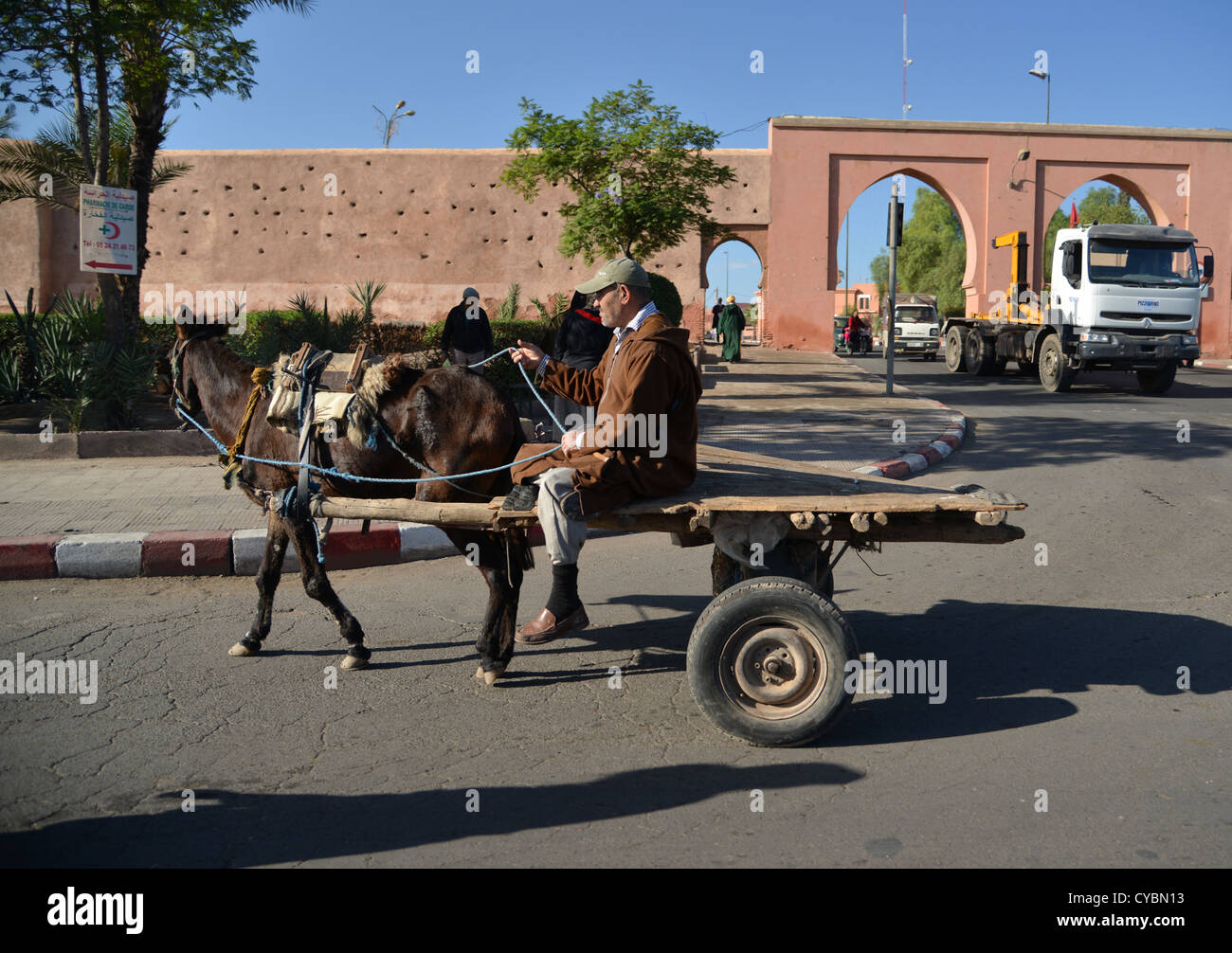 Man drivign a donkey cart on the streets of Marakesh, Morocco (Marakech), a modern truck in the background Stock Photo