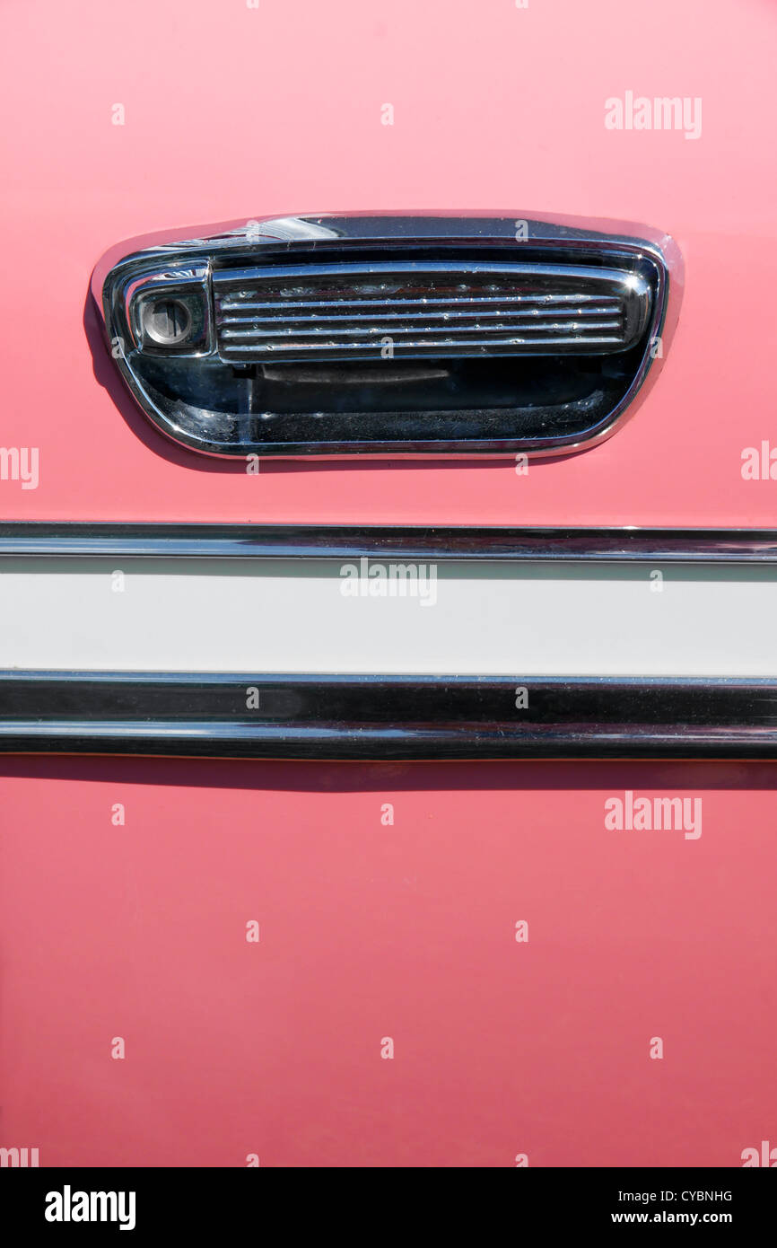 Close up on the handle and chrome decoration on an old pink vintage car; great background. Stock Photo