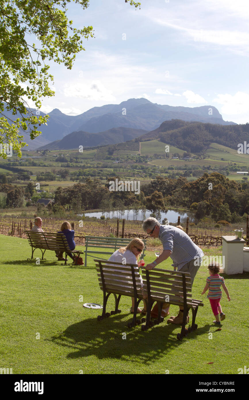 Visitors enjoy wine and a view of the valley from the lawns of La Petite Ferme restaurant, Franschhoek, South Africa. Stock Photo