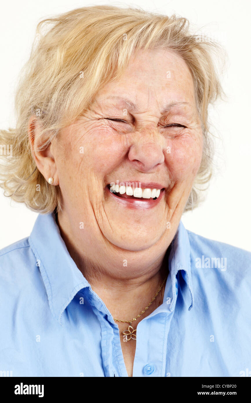 Portrait of a blond senior woman laughing hysterically or giggling. Stock Photo
