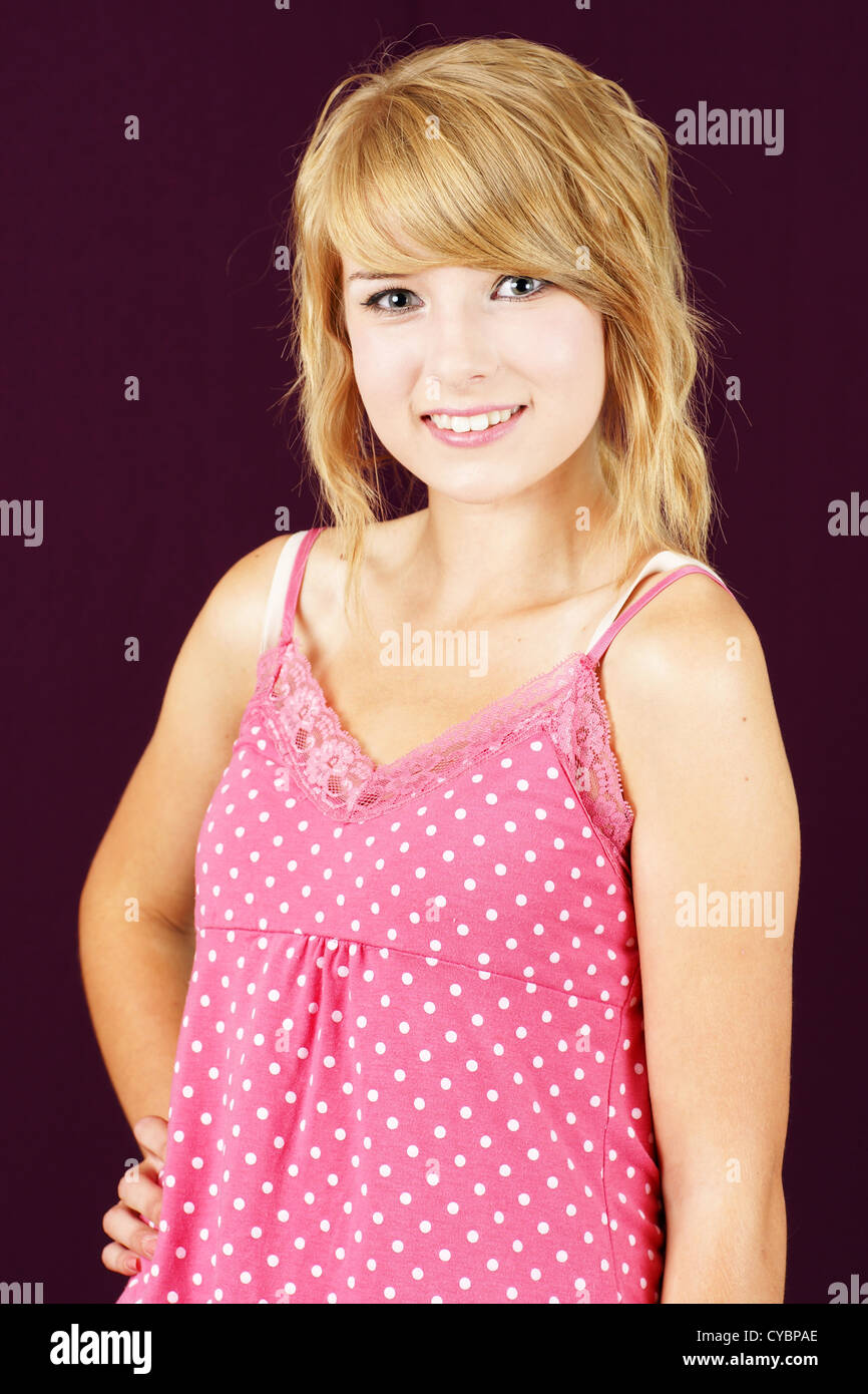 Portrait of cute and innocent young blond teenager girl smiling, studio  shot over deep pink or purple background Stock Photo - Alamy