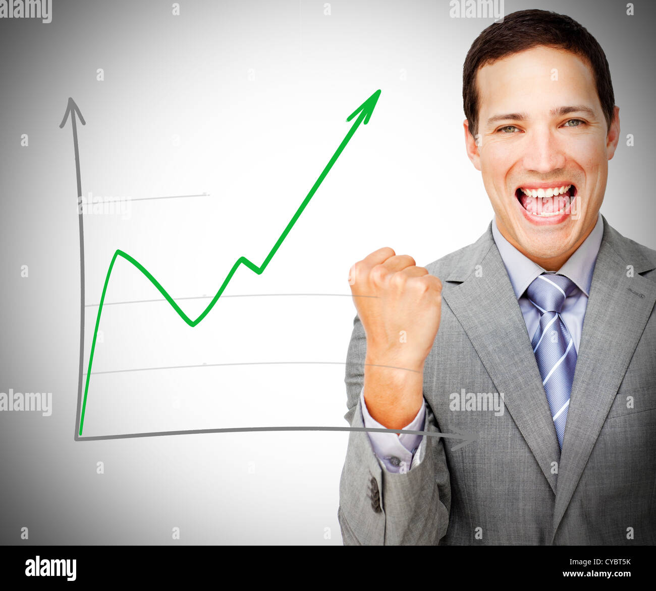 Businessman celebrating behind increasing graph Stock Photo
