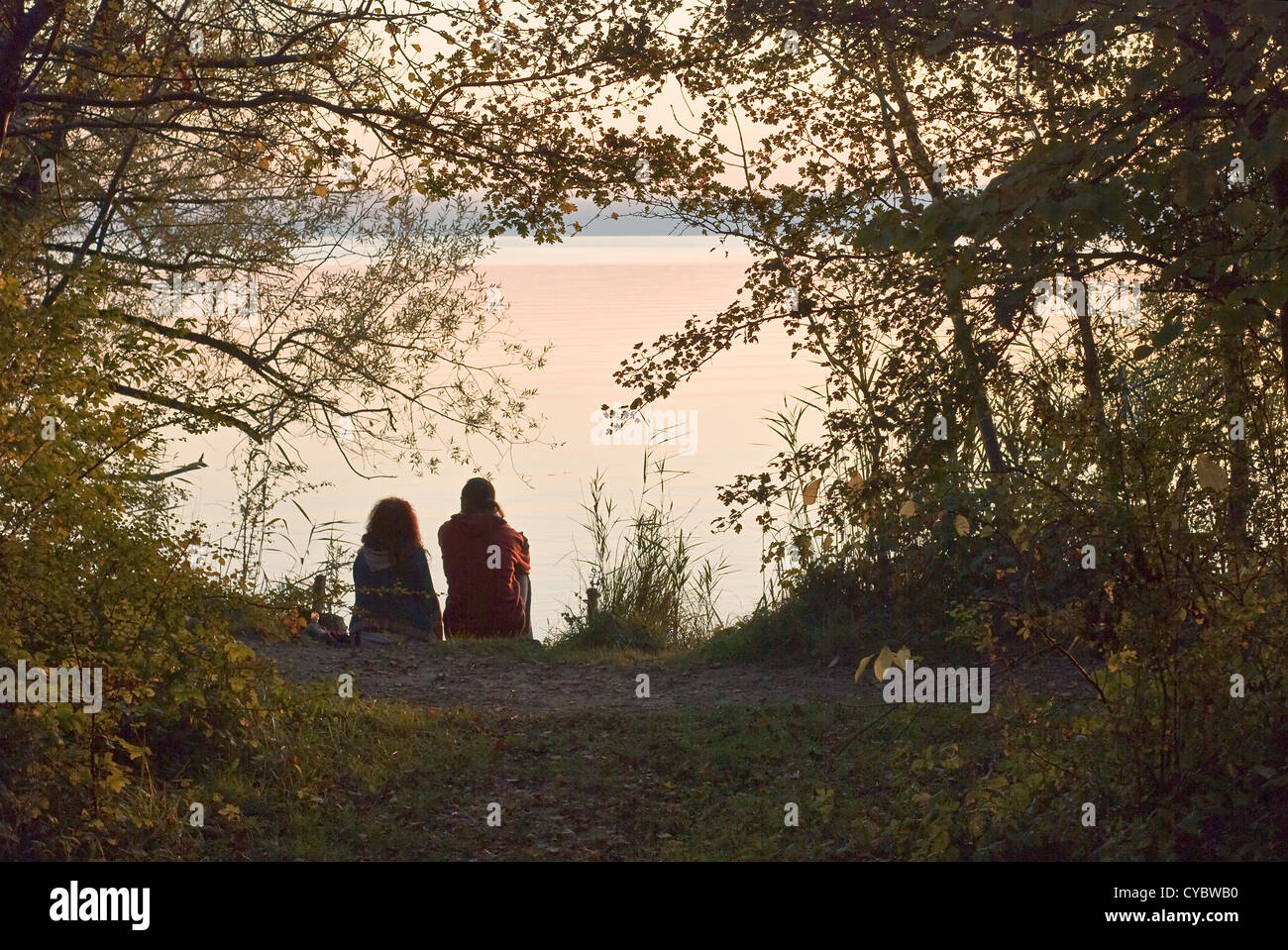 Silhouette of Romantic Couple on Lake at Sunset Stock Photo - Alamy