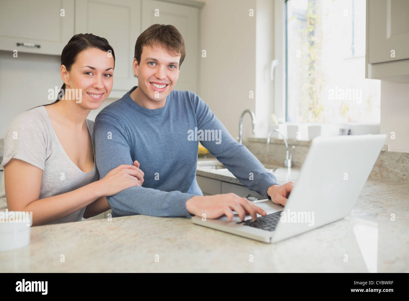 Happy young couple using laptop Stock Photo - Alamy