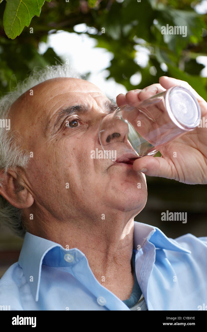 portrait of elderly man drinking from glass Stock Photo