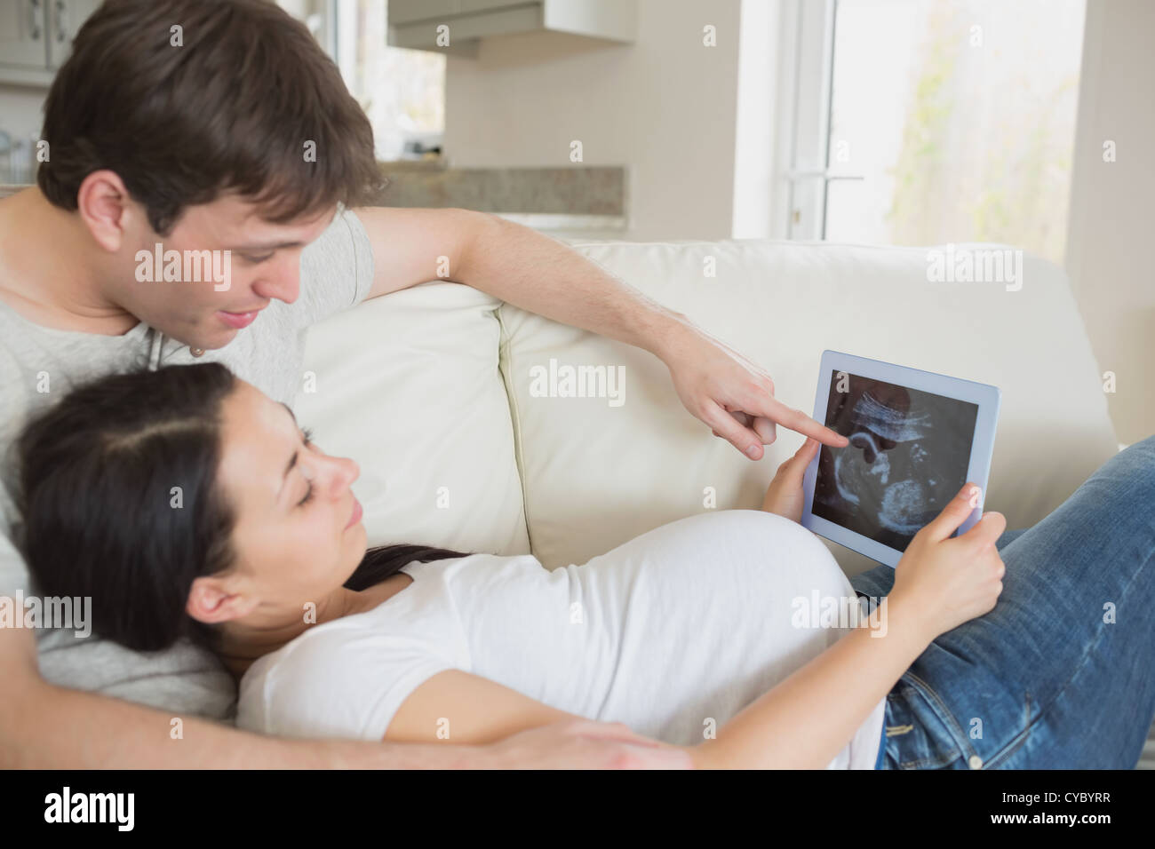 Prospective parents looking at ultrasound scan on tablet pc Stock Photo