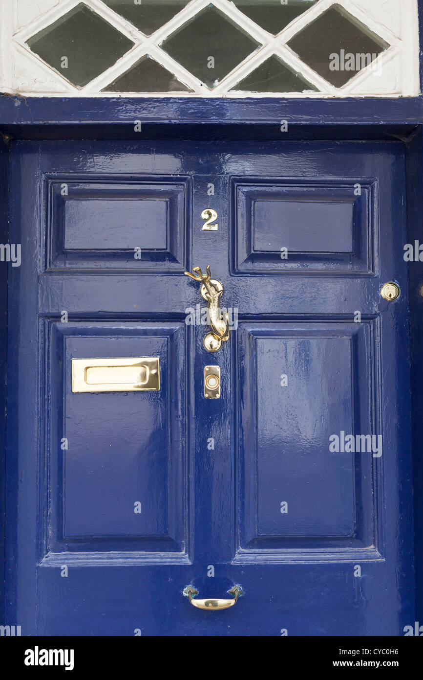 Blue front door with polished brass ironmongery Stock Photo