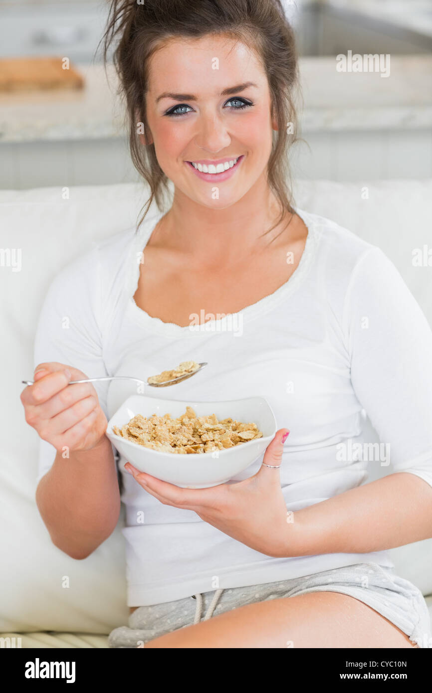 Smiling girl eating bowl of cereal Stock Photo Alamy