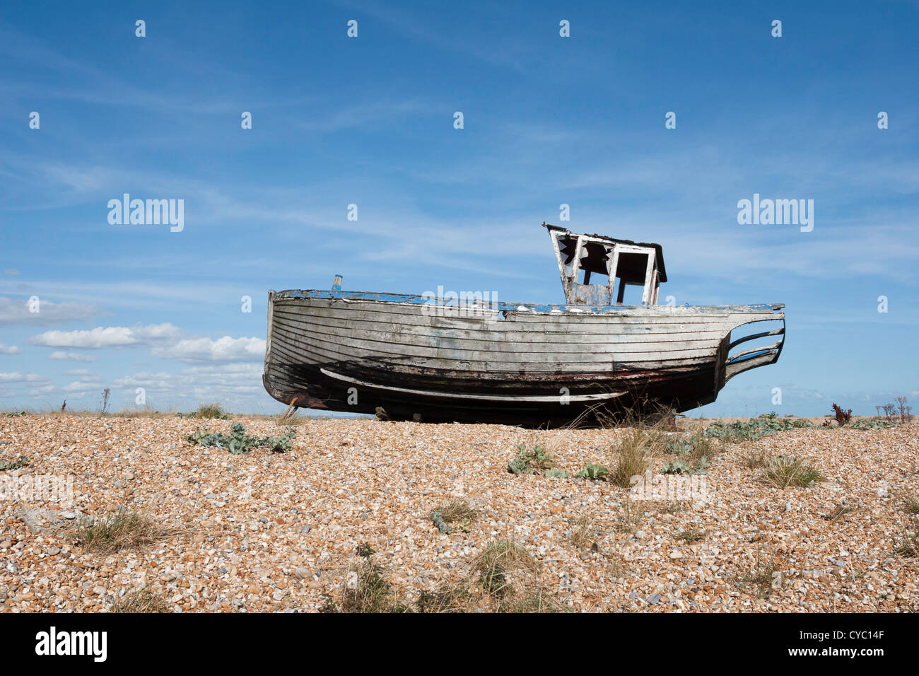 Old fishing boat marooned on the shingle beach at Dungeness in Kent ...