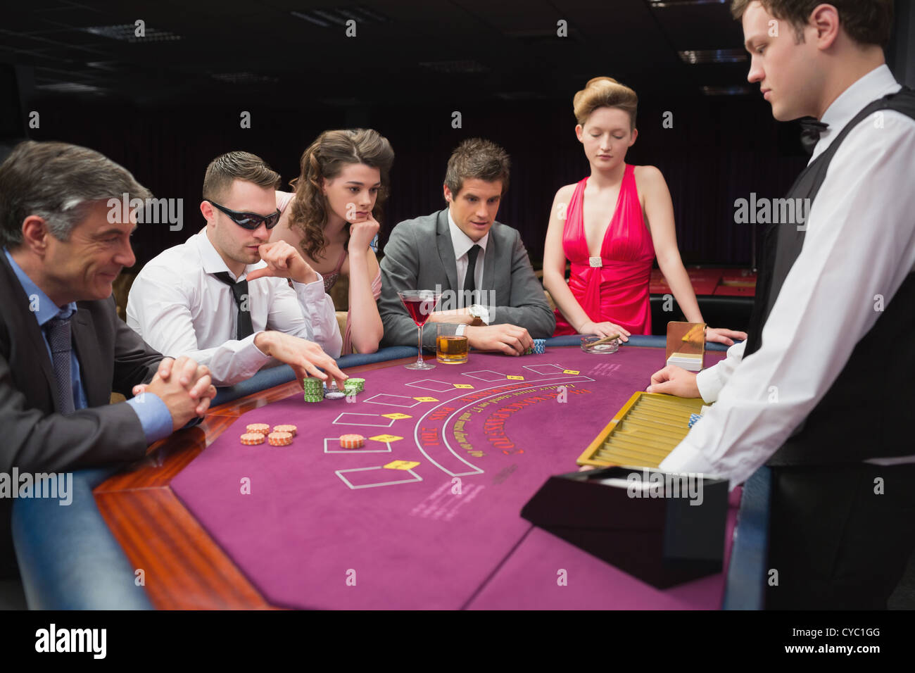 People sitting at table playing poker Stock Photo