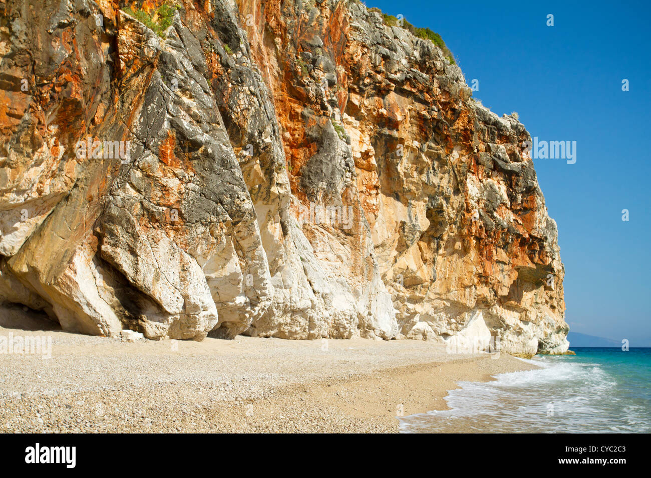 Beautiful sunny beach surrounded by high cliff wall Stock Photo