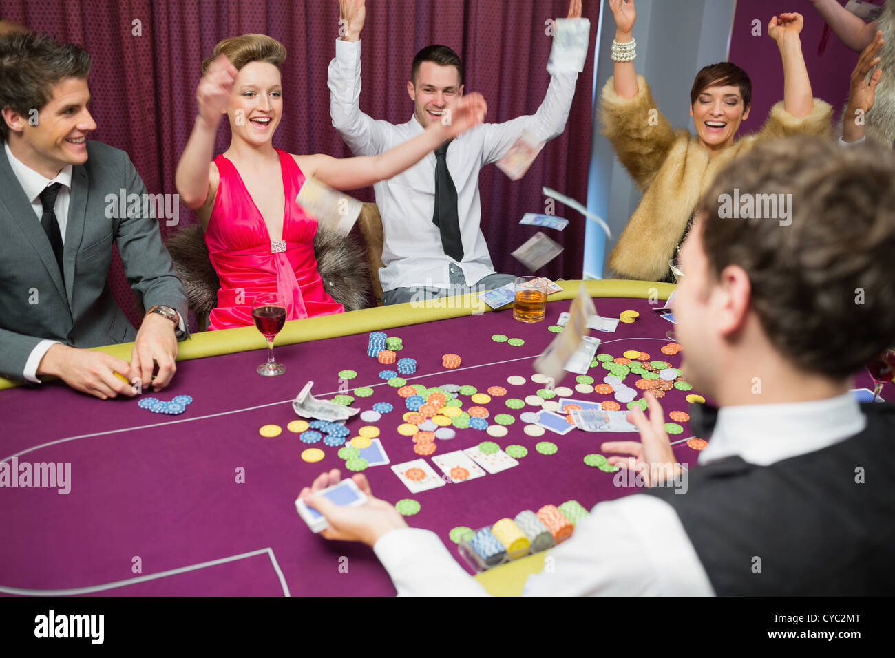 People celebrating at poker game Stock Photo