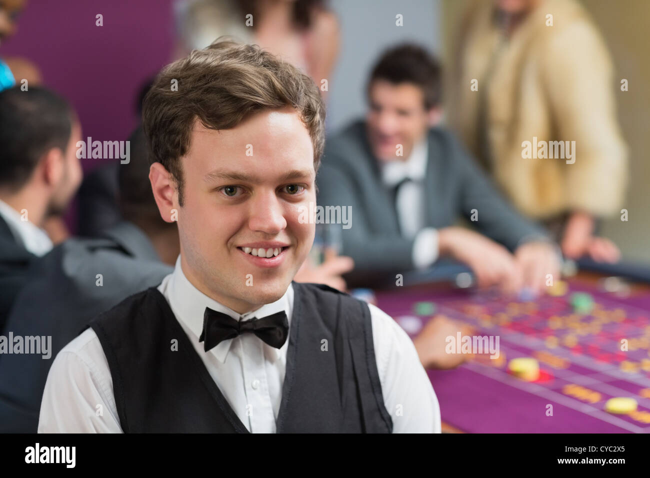 Dealer standing at roulette table Stock Photo Alamy