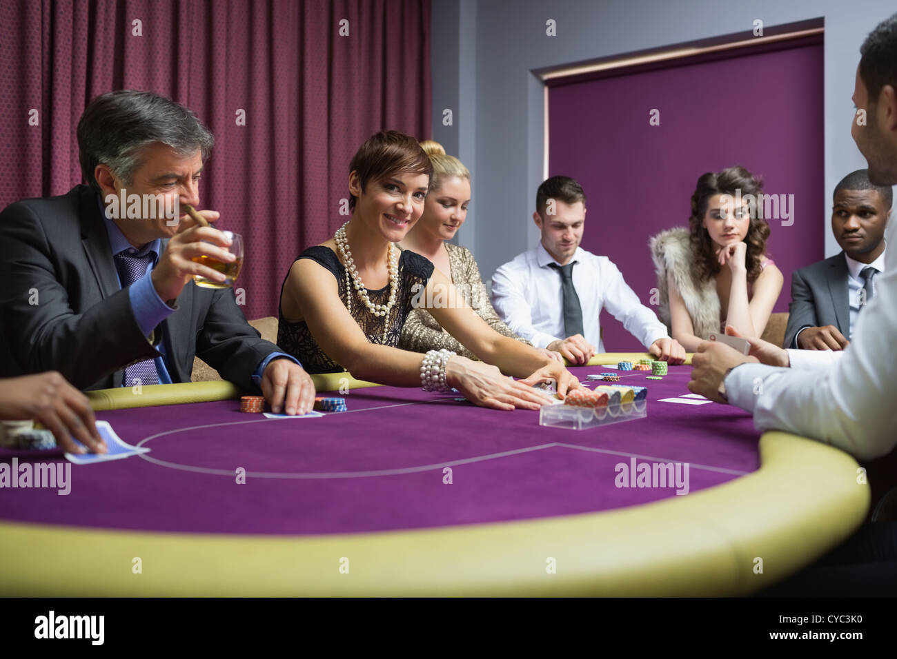 Woman looking up from poker game Stock Photo