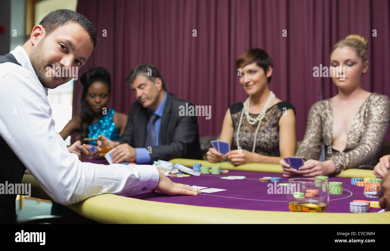 Dealer smiling at poker game Stock Photo