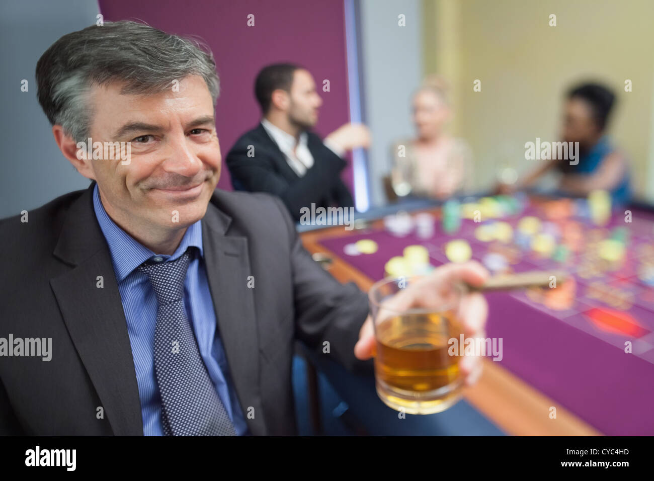 Man with whiskey glass at roulette table Stock Photo Alamy