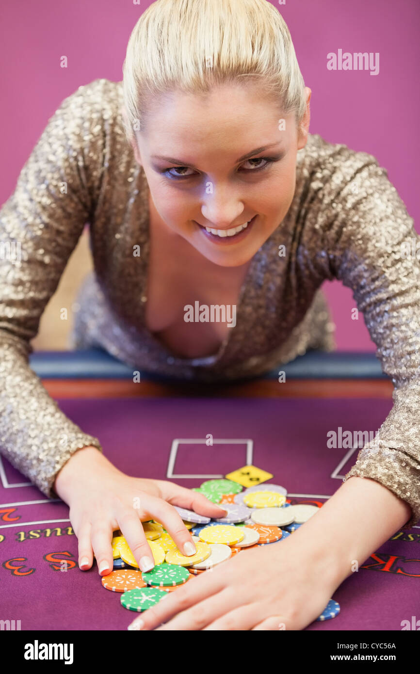 Smiling woman taking chips Stock Photo