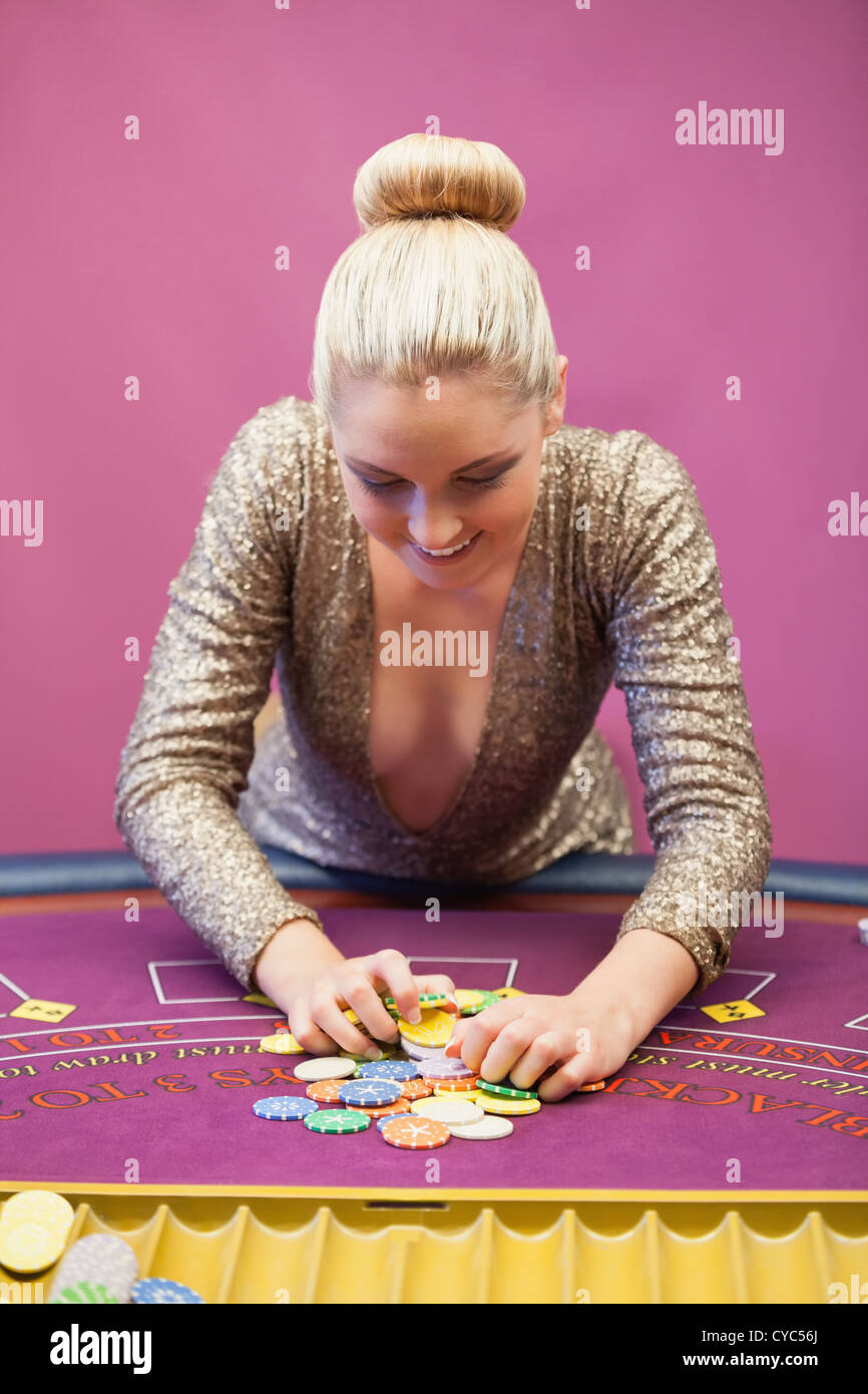 Woman in a casino grabbing chips Stock Photo