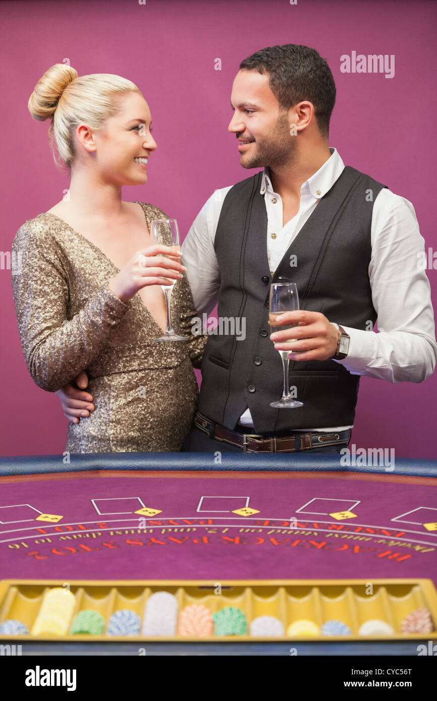 Couple drinking champagne at poker table Stock Photo