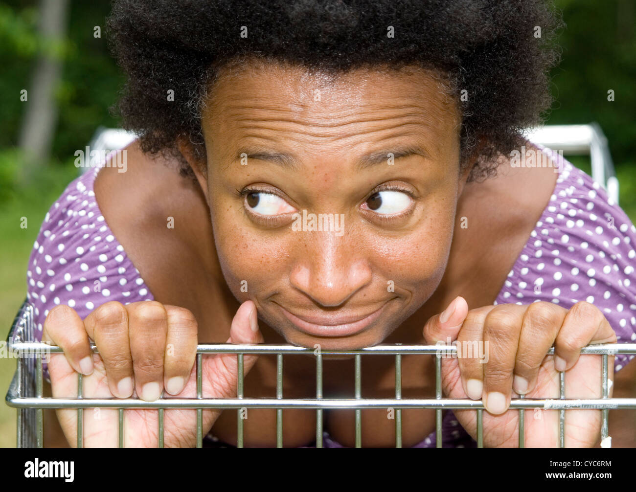 Closeup of African American woman with an afro in a grocery cart making a comic face Stock Photo
