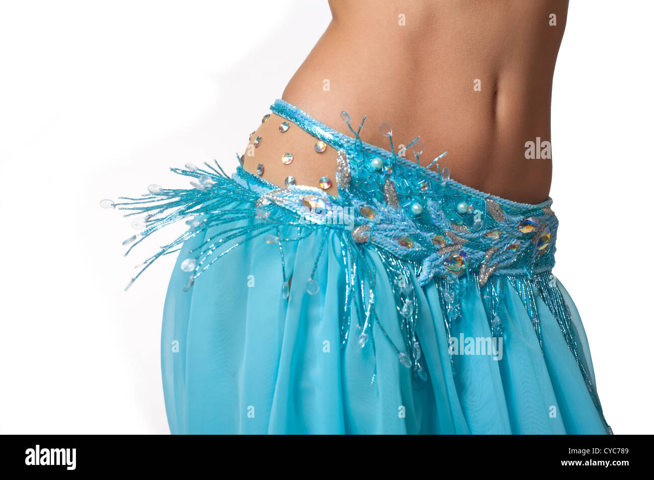 Close up shot of a belly dancer wearing a light blue costume shaking her hips. Isolated on white. Stock Photo
