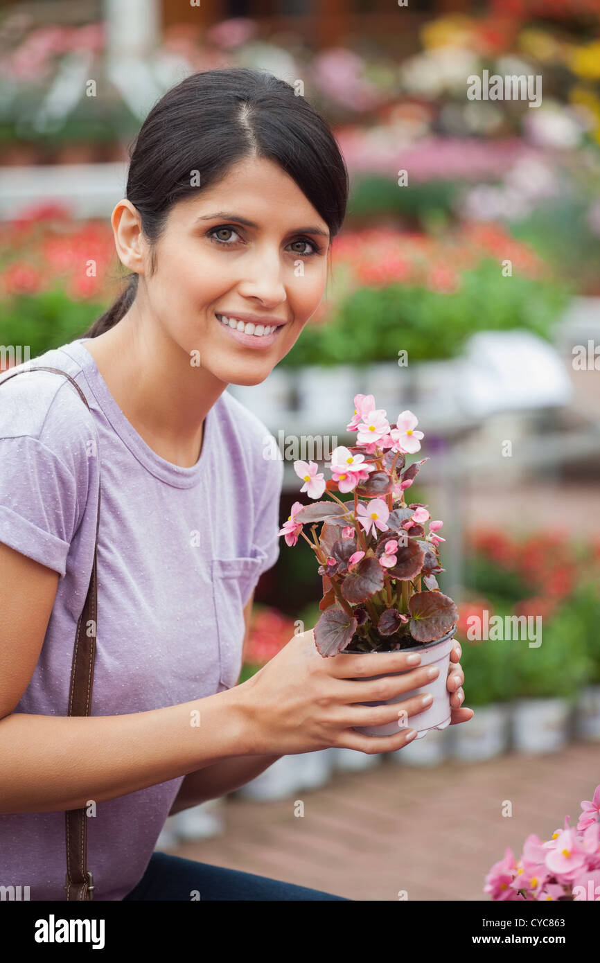 Woman holding a flower while smiling Stock Photo - Alamy