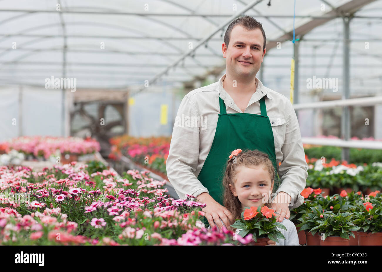 Little girl and gardener standing in greenhouse Stock Photo - Alamy