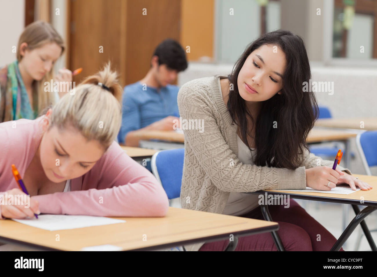 Girl copying another students work in exam Stock Photo