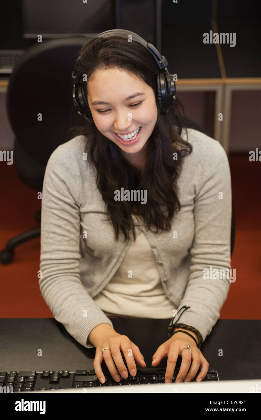 Female student sitting at the computer with headphones Stock Photo - Alamy