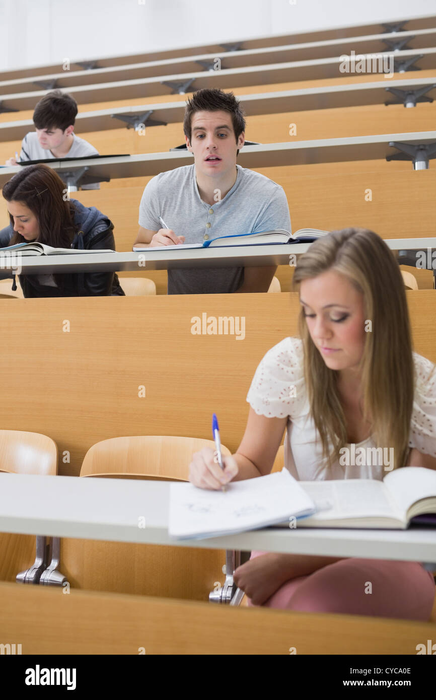 Student looking at another's work in lecture hall Stock Photo