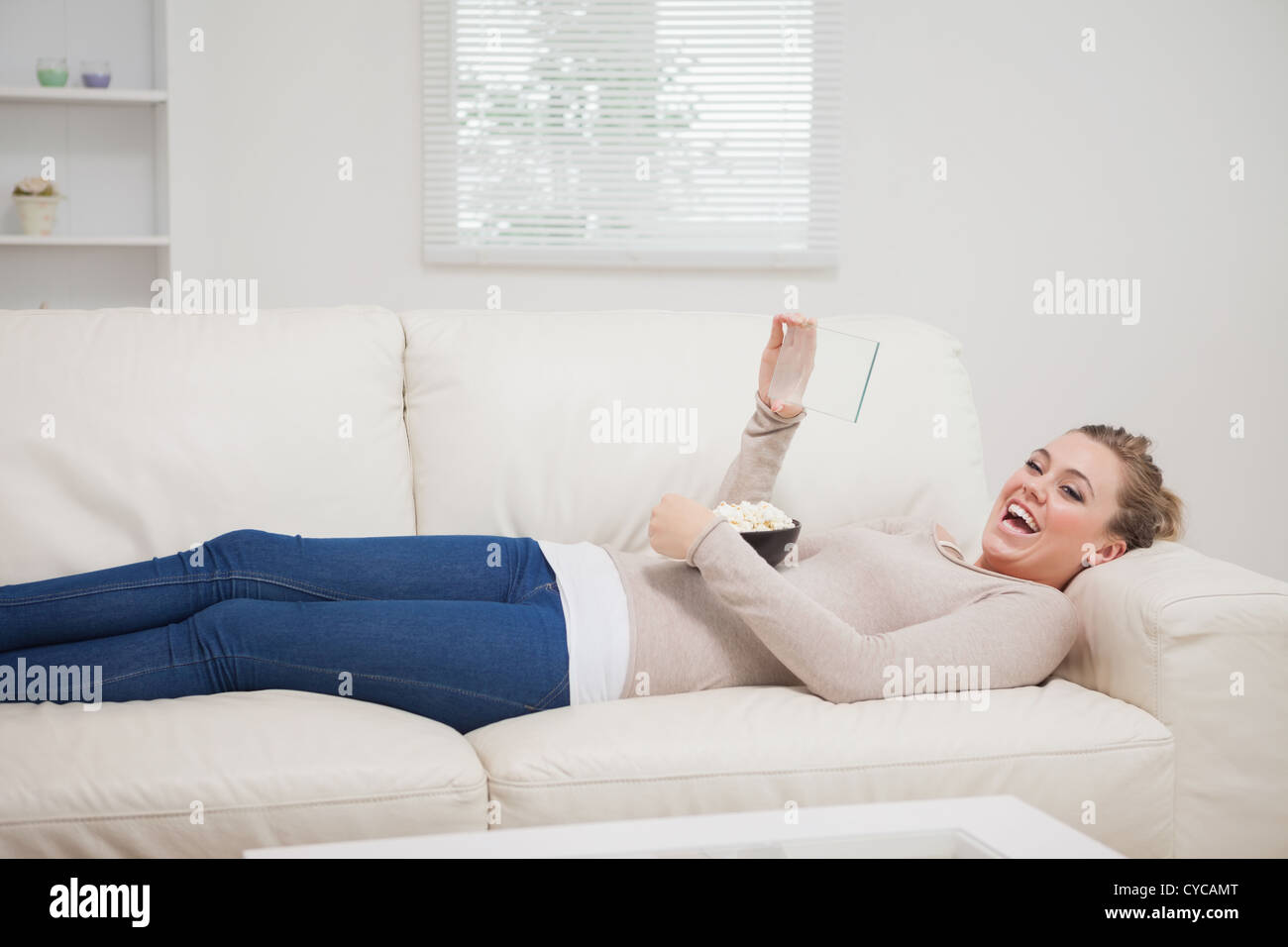 Woman laughing at the clear pane while lying down Stock Photo Alamy