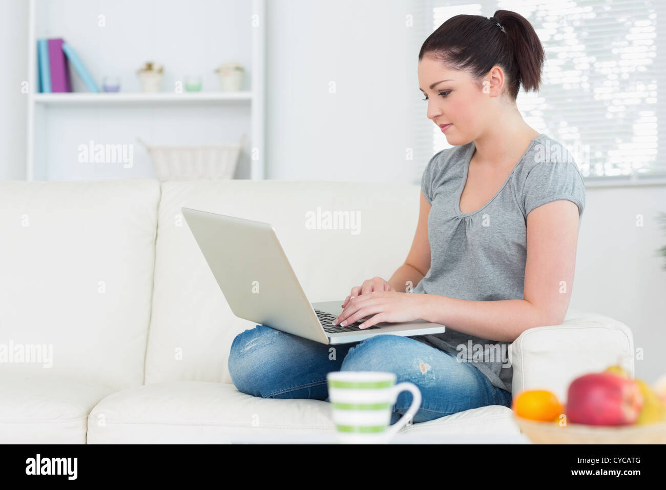 Relaxing woman on the couch using a laptop Stock Photo - Alamy