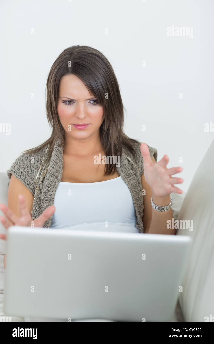Woman looking wary of laptop Stock Photo
