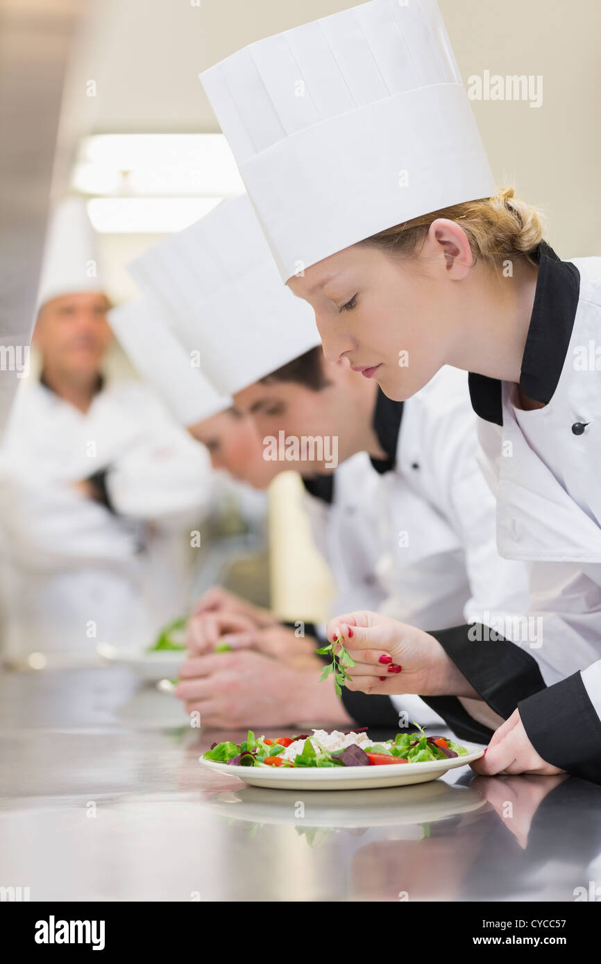 Chef's applying finishing touches to salads Stock Photo