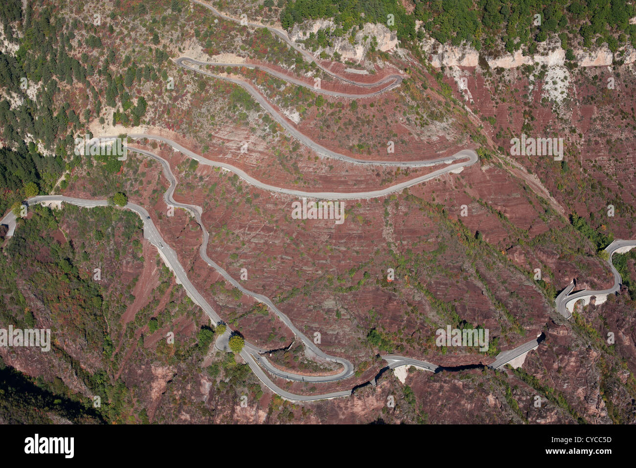 AERIAL VIEW. Winding road on the distinctive red rock of the Daluis Gorge. Guillaumes, Var Valley, French Riviera's hinterland, France. Stock Photo