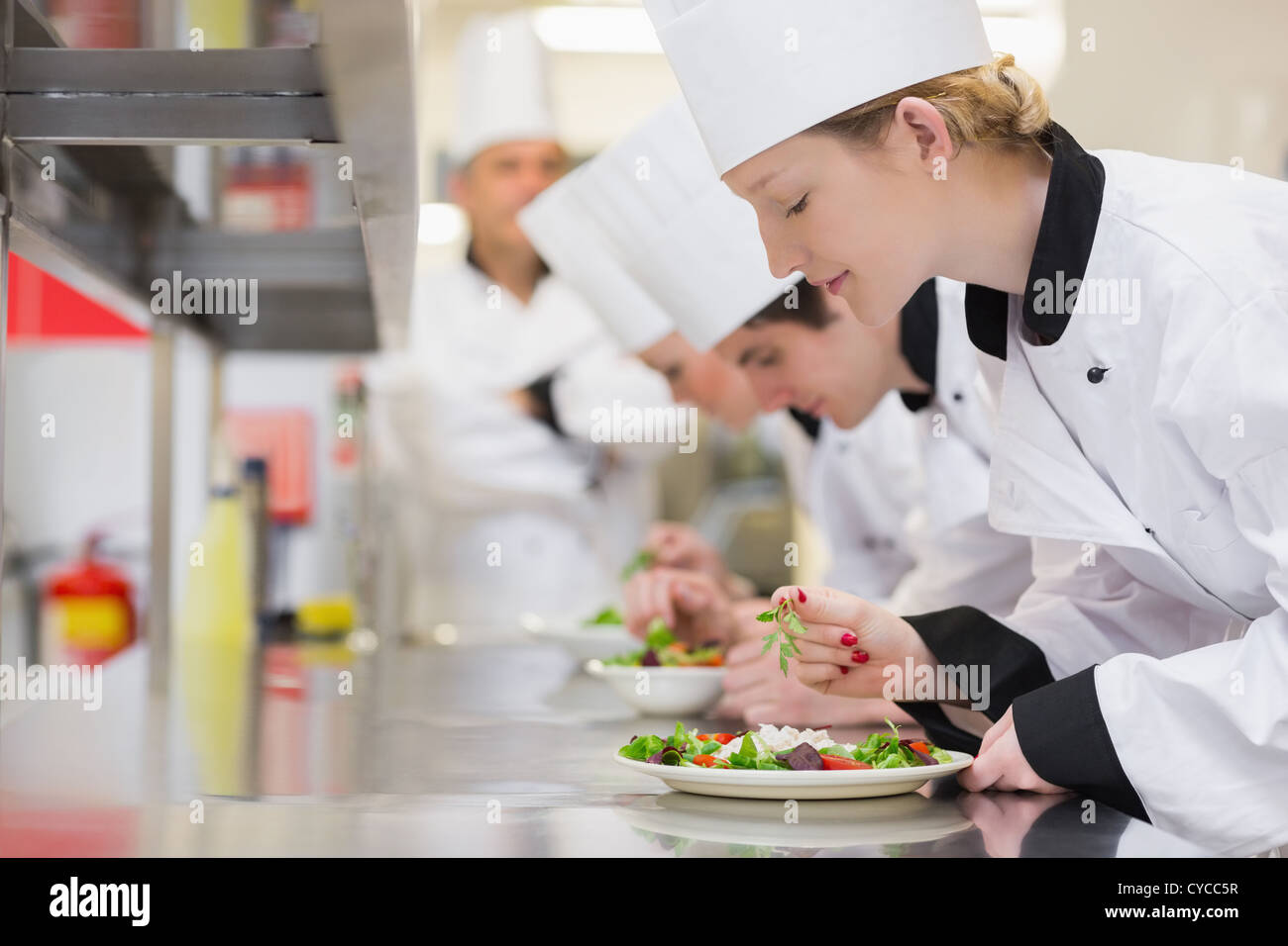 Chef's finishing their salads in culinary class Stock Photo